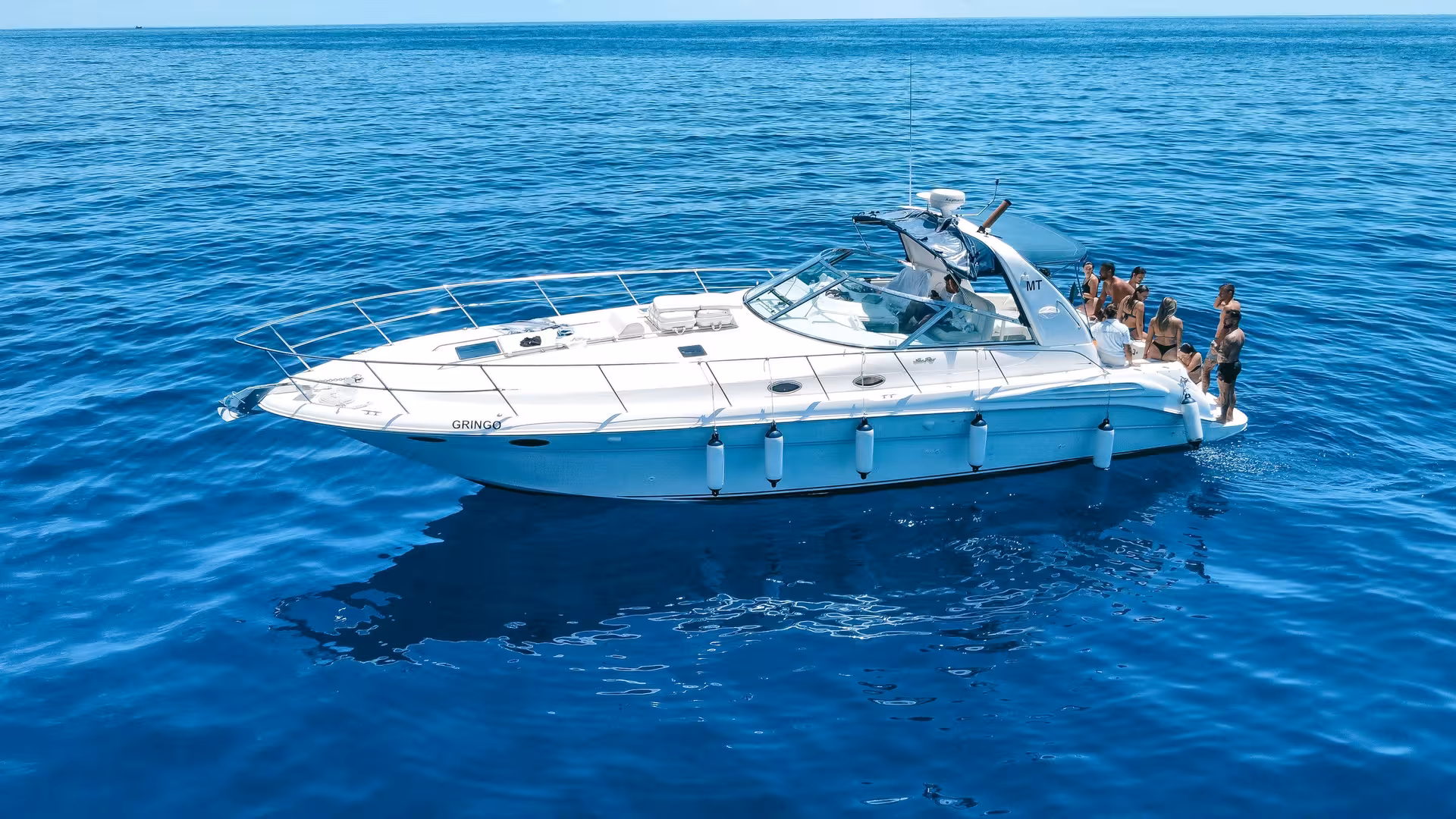 The GRINGO Yacht sails through clear blue waters, a perfect setting for a private charter full-day adventure.