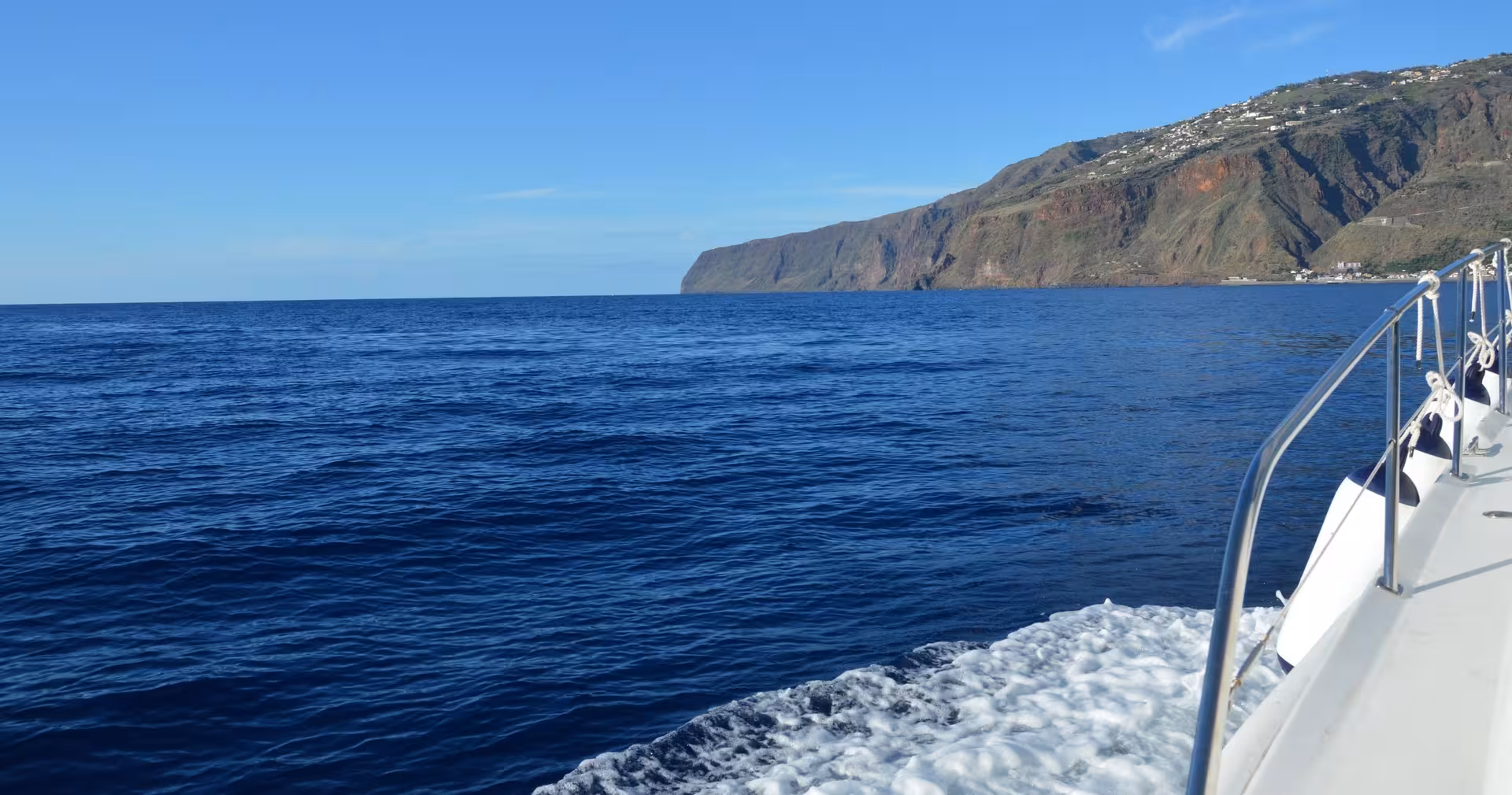 Experience the stunning coastal views from the GRINGO yacht on a private charter, cruising along clear blue waters.