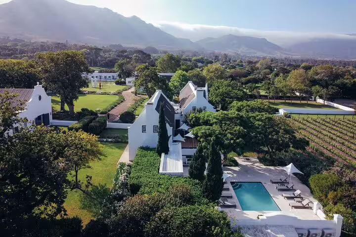 Aerial view of Groot Constantia Estate with lush vineyards and pool, showcasing Cape Town's scenic wine country.