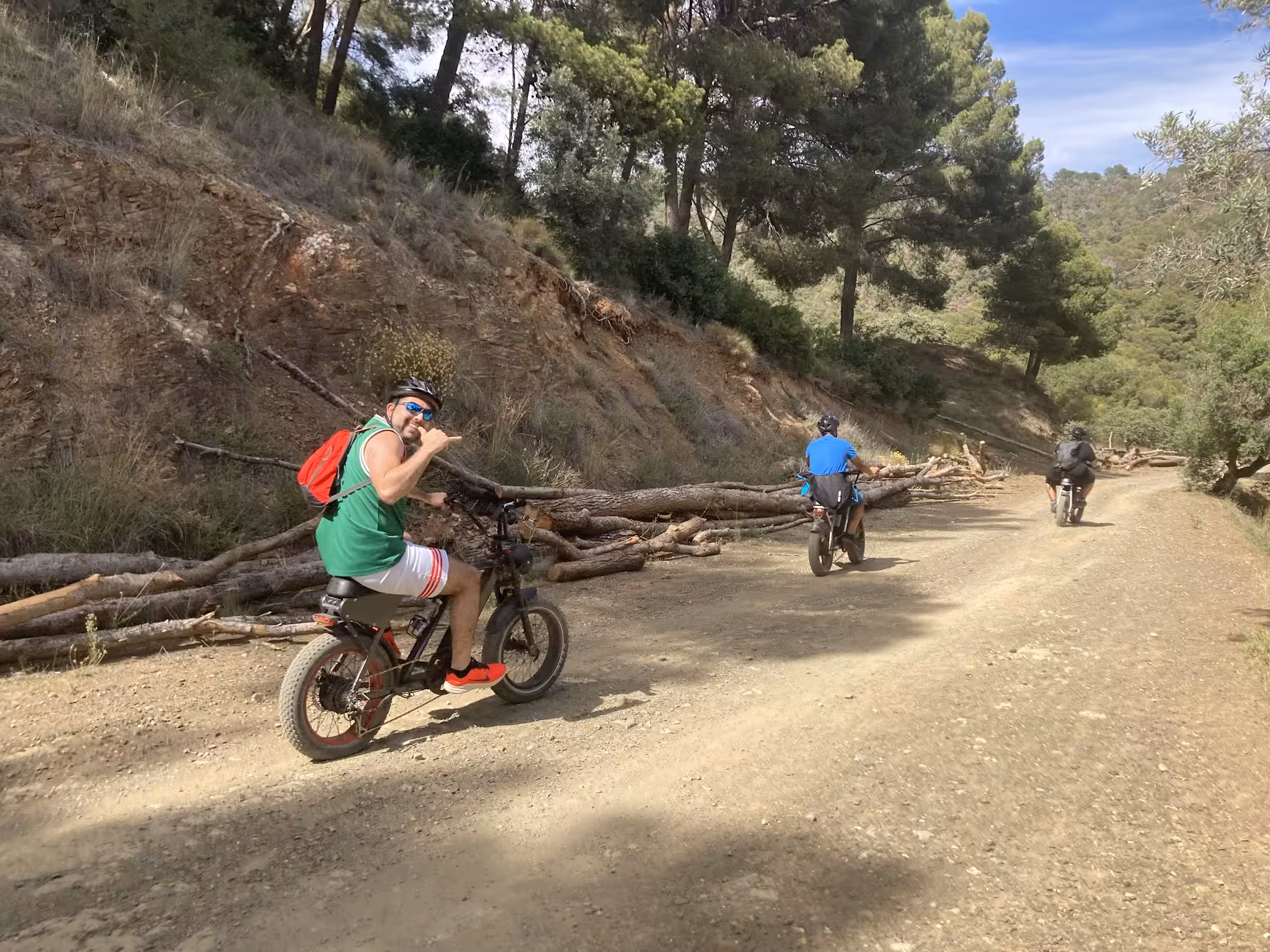 Group riding e-fat bikes on a pine forest dirt trail, ideal for a 4-hour e-bike rental with scenic viewpoints