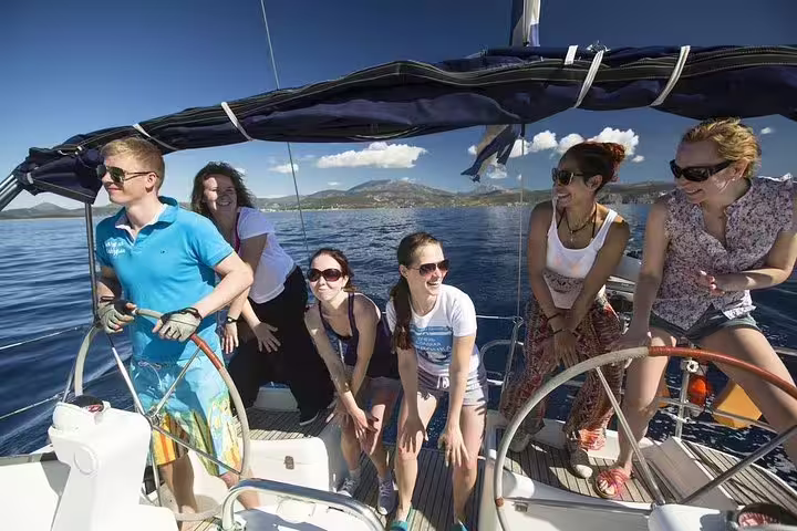 Group enjoying a sunny 3-hour sailing trip with tapas and drinks, surrounded by stunning ocean views and clear blue skies.