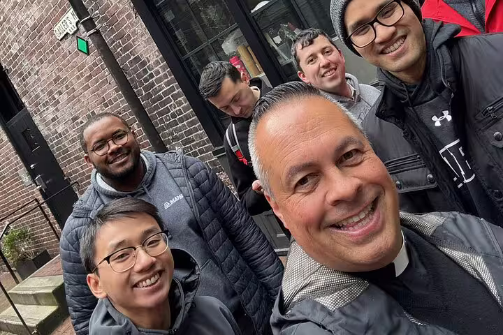 Group of smiling friends taking a selfie on a brick-lined street in Vancouver Gastown