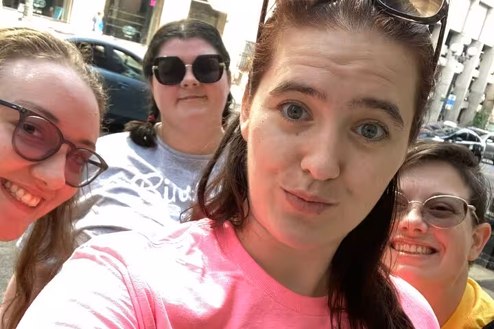 Four women taking a selfie outdoors on a sunny day during a walking tour in Seattle