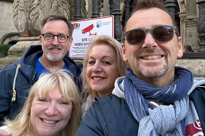 Four smiling adults taking a selfie during a walking tour in Luxembourg City