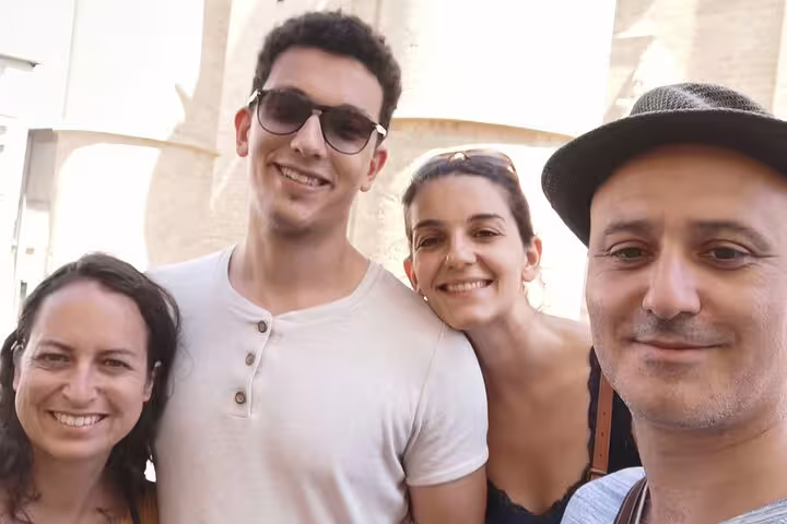 Four smiling tourists posing for a selfie during a walking tour in Montpellier