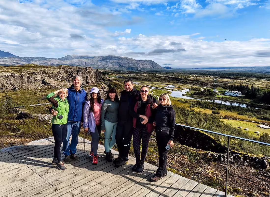 Group of six tourists posing at Þingvellir National Park viewpoint on Iceland Golden Circle tour