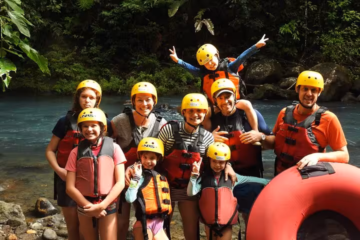 Happy group of adventurers in life jackets and helmets ready for tubing along the scenic Celeste River.