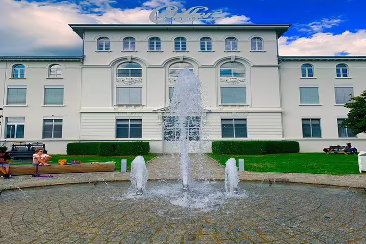 Elegant white building with fountain, part of Bern Small Group Tour featuring Gruyères Castle, cheese, and chocolate.