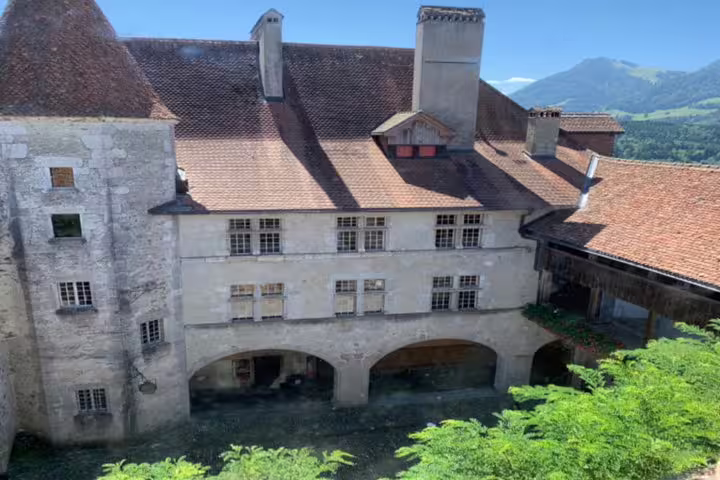Historic Gruyères Castle with rustic red roofs and scenic mountain views, featured on the Bern small group tour.