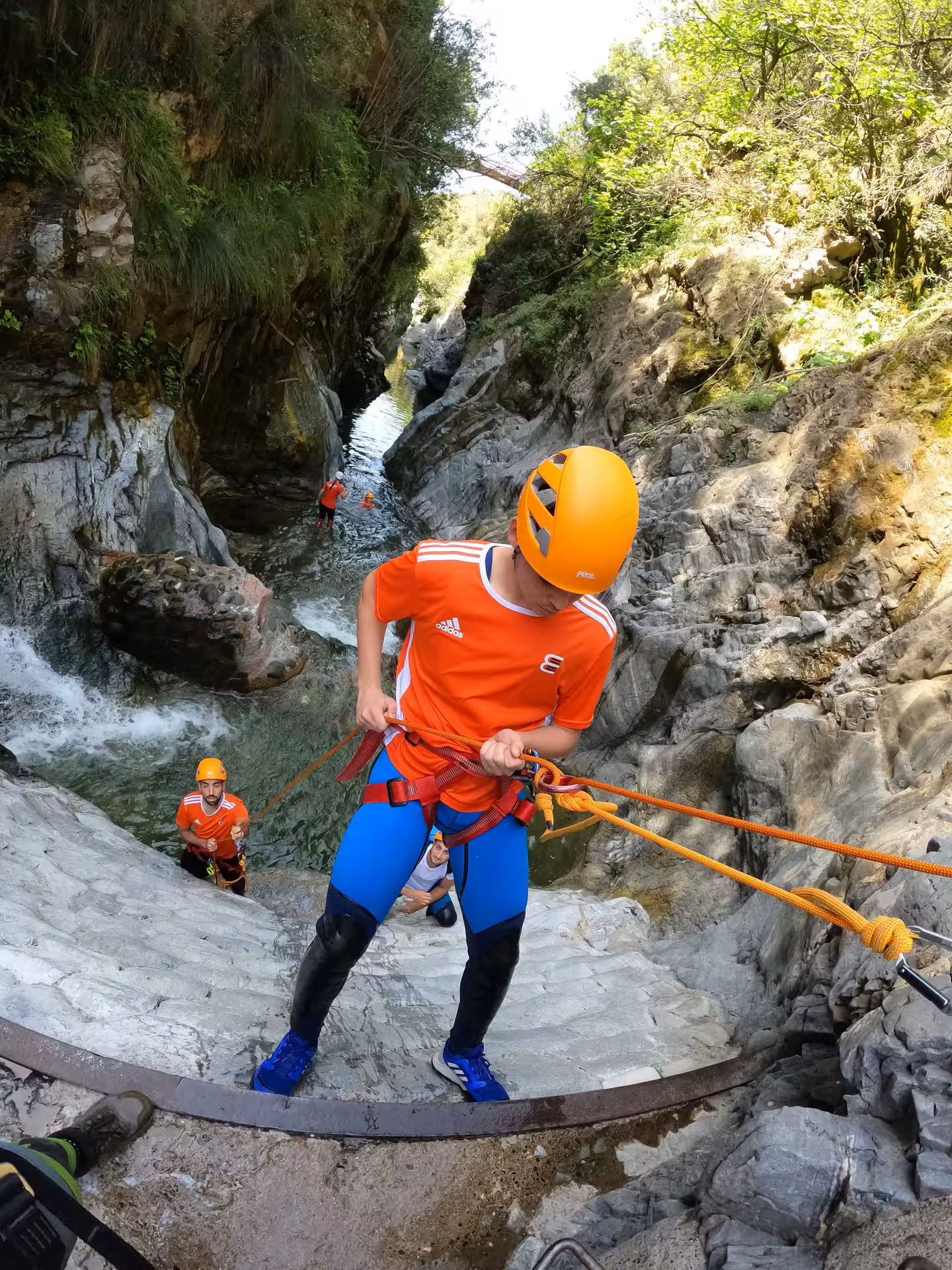 Group of canyoners rappelling wet rock faces with safety ropes on a guided Guadalmina Canyon tour Estepona