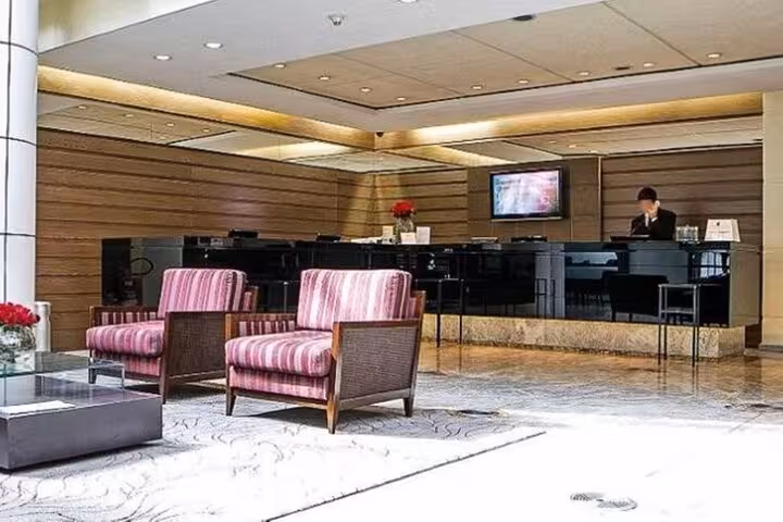 Modern hotel lobby in São Paulo with comfortable seating, ideal for relaxing after a private airport transfer.