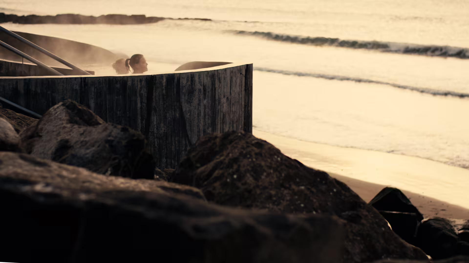 Guests enjoying a bath in the Guðlaug Geothermal Bath