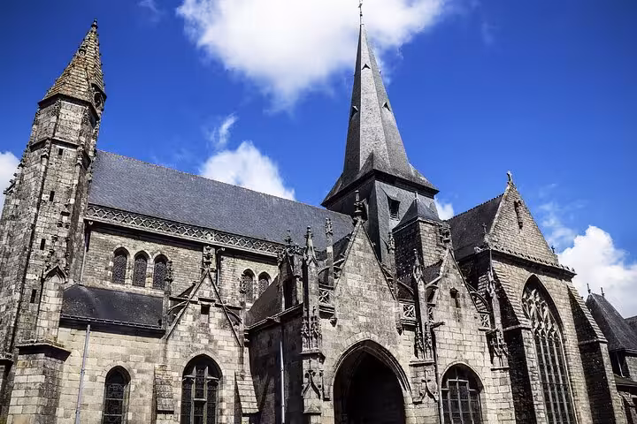 Gothic stone church with tall spire and ornate carvings in Guérande, France