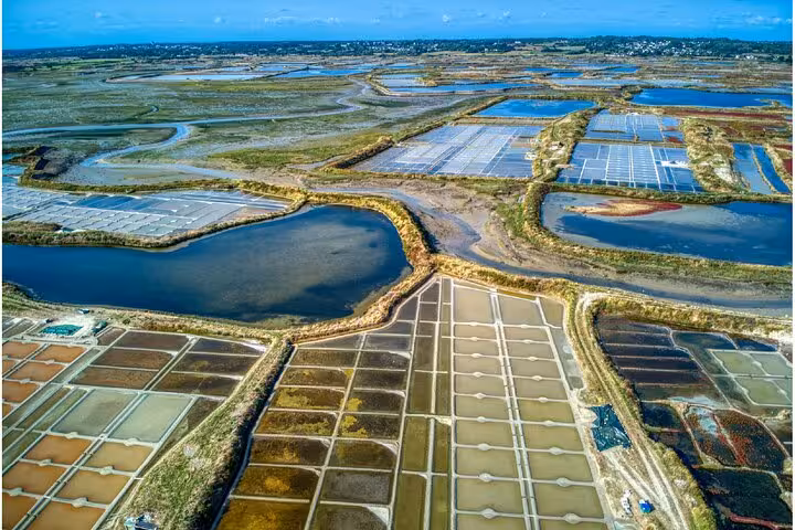 Aerial view of Guérande salt marshes with geometric evaporation ponds and waterways in Loire-Atlantique, France