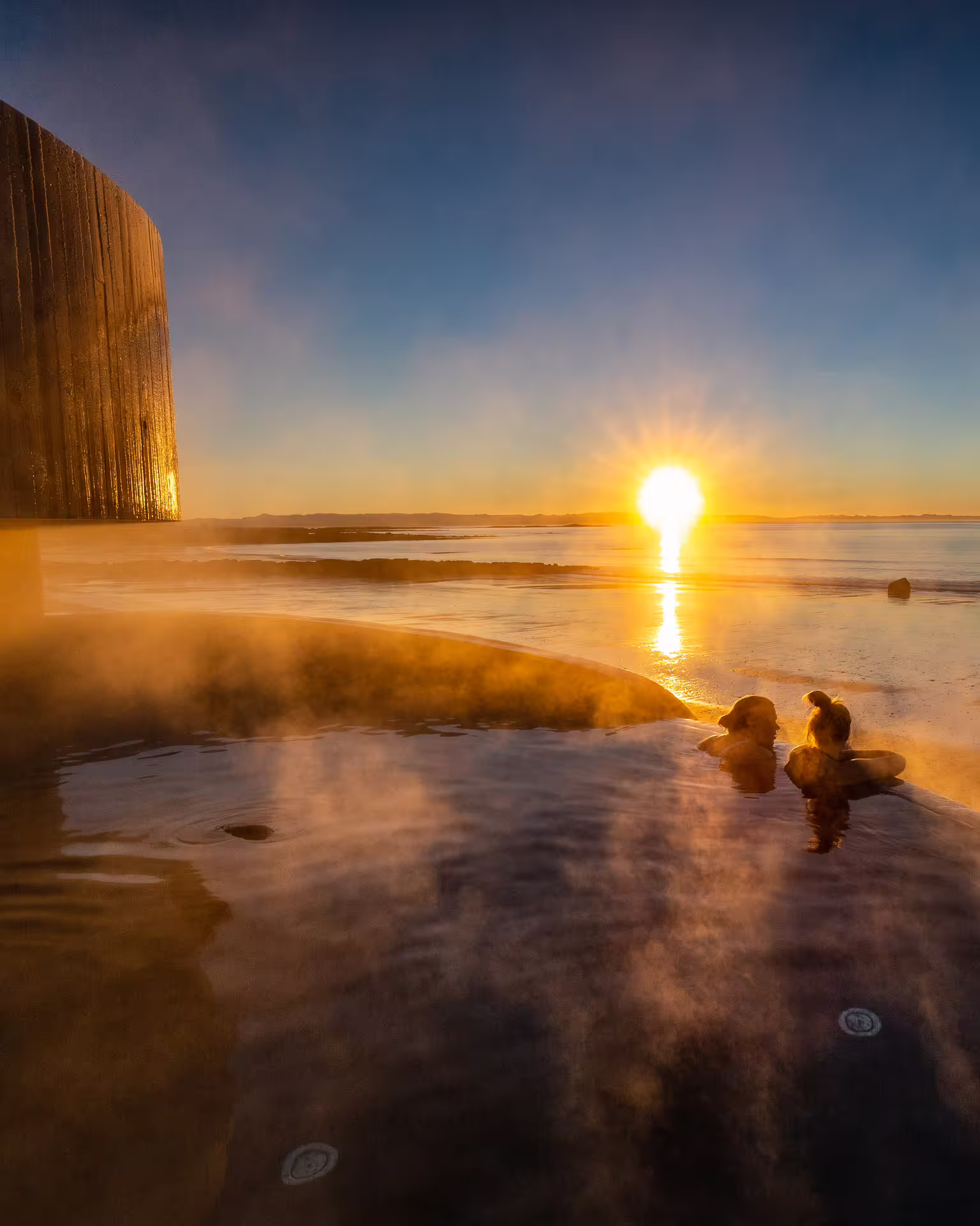 A picture of guests taking a bath in the Guðlaug Geothermal Baths