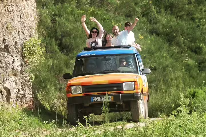 Adventurous tourists enjoy a thrilling 4x4 ride through the lush landscapes of southwest Madeira on a guided exploration tour.