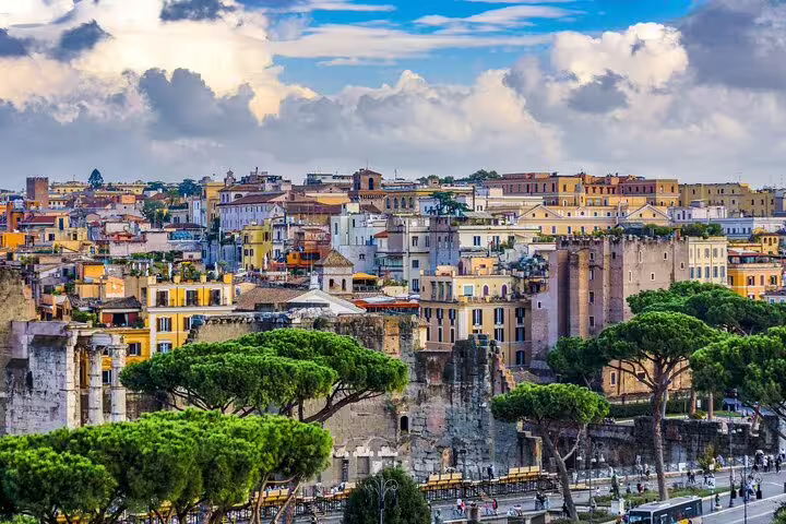 Panoramic view of central Rome with ancient ruins, colorful houses and umbrella pines on a guided early morning tour