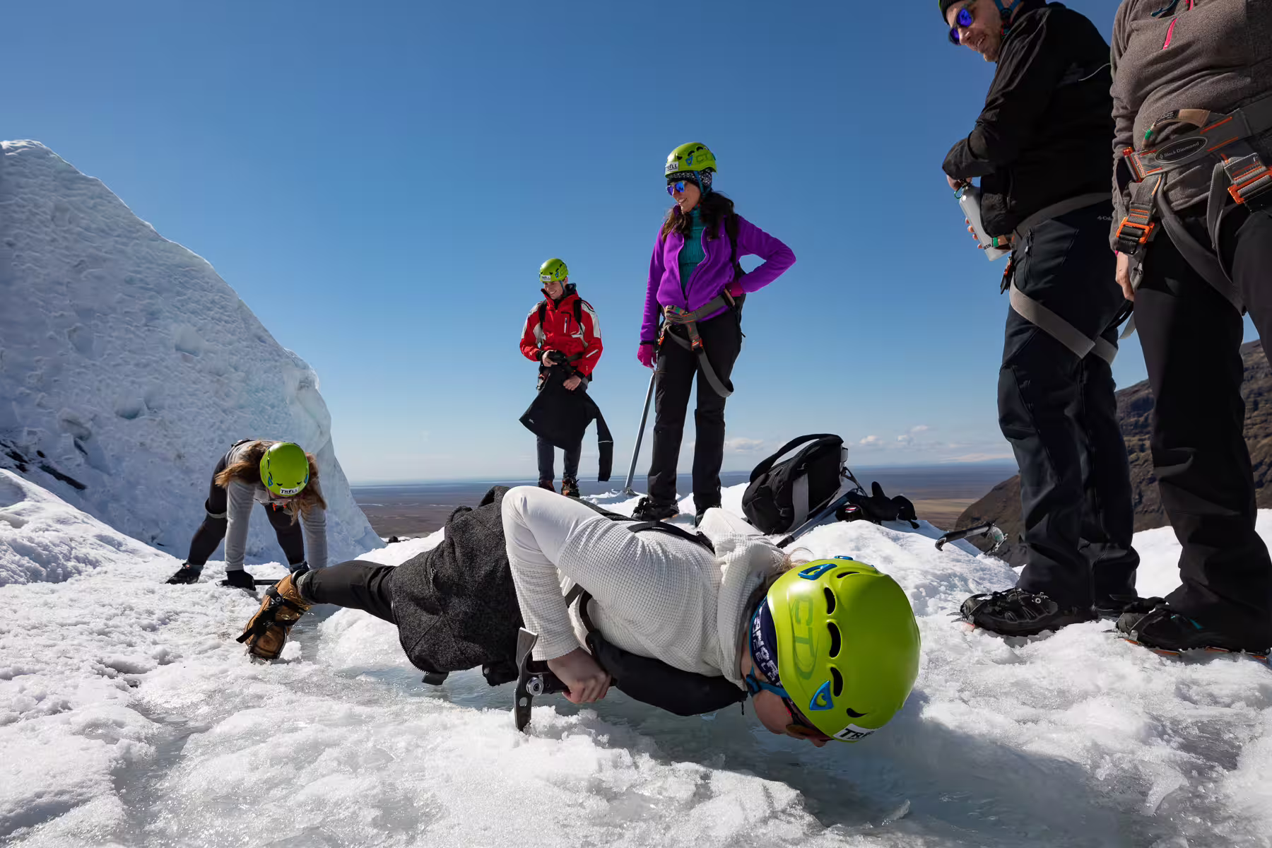 Group of tourists in helmets and crampons practicing glacier hiking techniques on Skaftafell glacier, Iceland