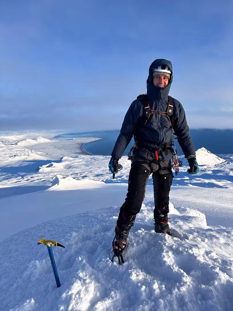 Mountaineer in full winter gear with crampons and ice axe on snowy Snaefellsjokull glacier summit, Iceland