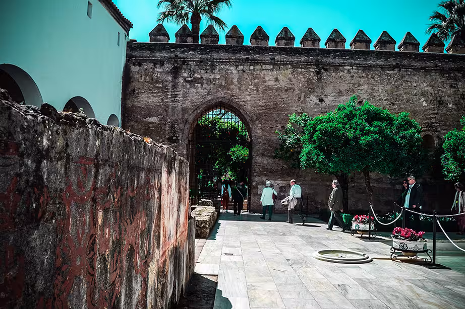 Visitors explore the historic Alcázar de los Reyes Cristianos, showcasing ancient architecture and lush gardens in Cordoba.