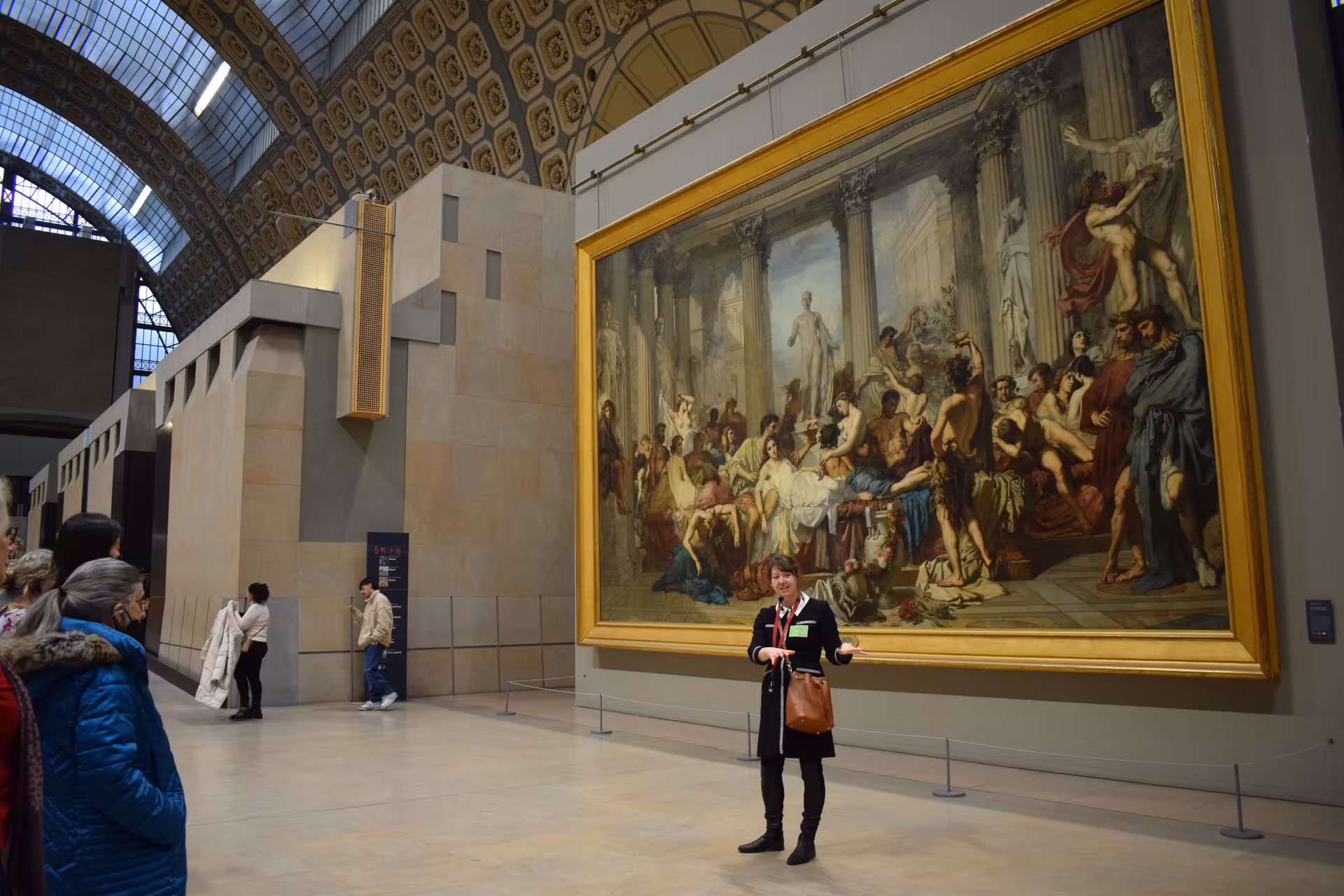 Tour guide presenting Romans of the Decadence painting at Musée d'Orsay Paris