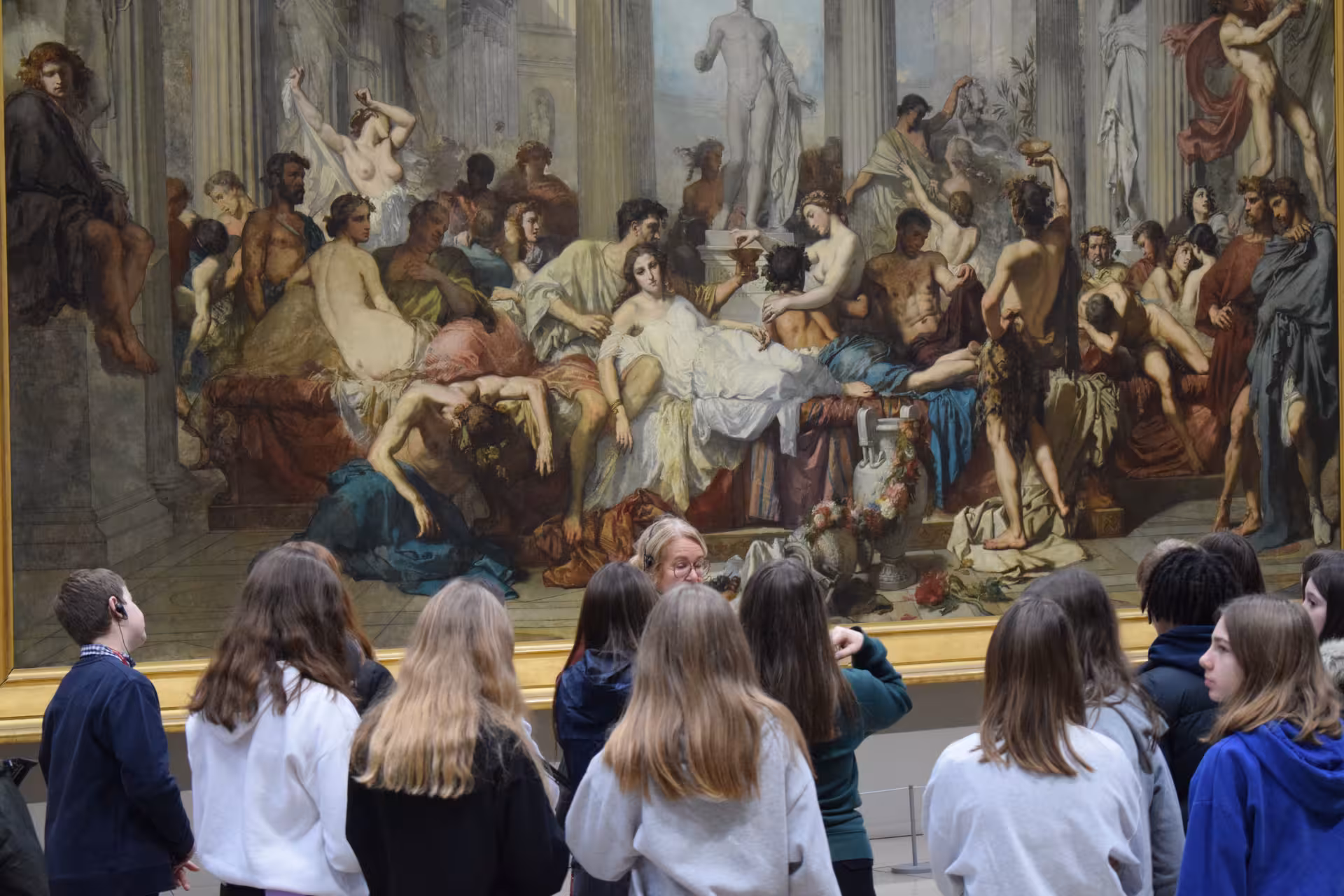 Student group with guide viewing large classical painting at Musée d'Orsay Paris