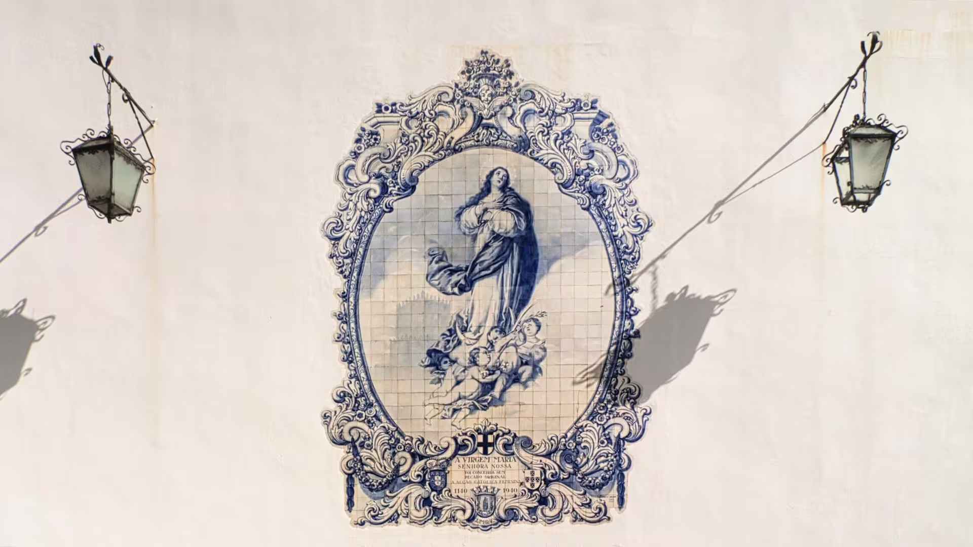 Intricate blue and white azulejo tile mural with religious motifs in Guimarães, Portugal, showcasing local art.