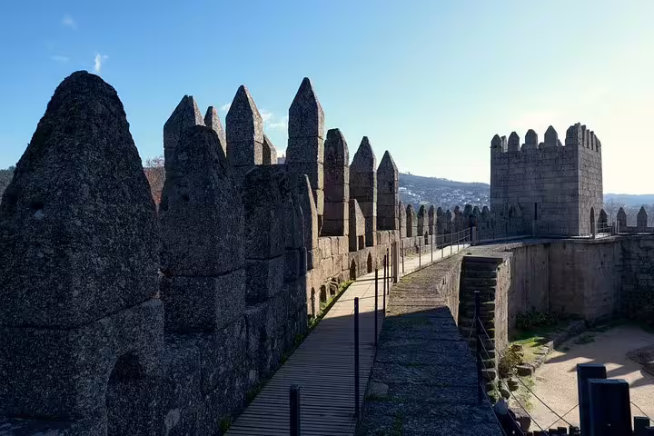 Stone battlements and tower of Guimarães Castle, a must-visit on a half-day private tour from Porto.