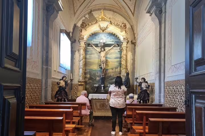 Tourists admire intricate religious art inside a historic chapel in Guimarães on a tour from Porto.