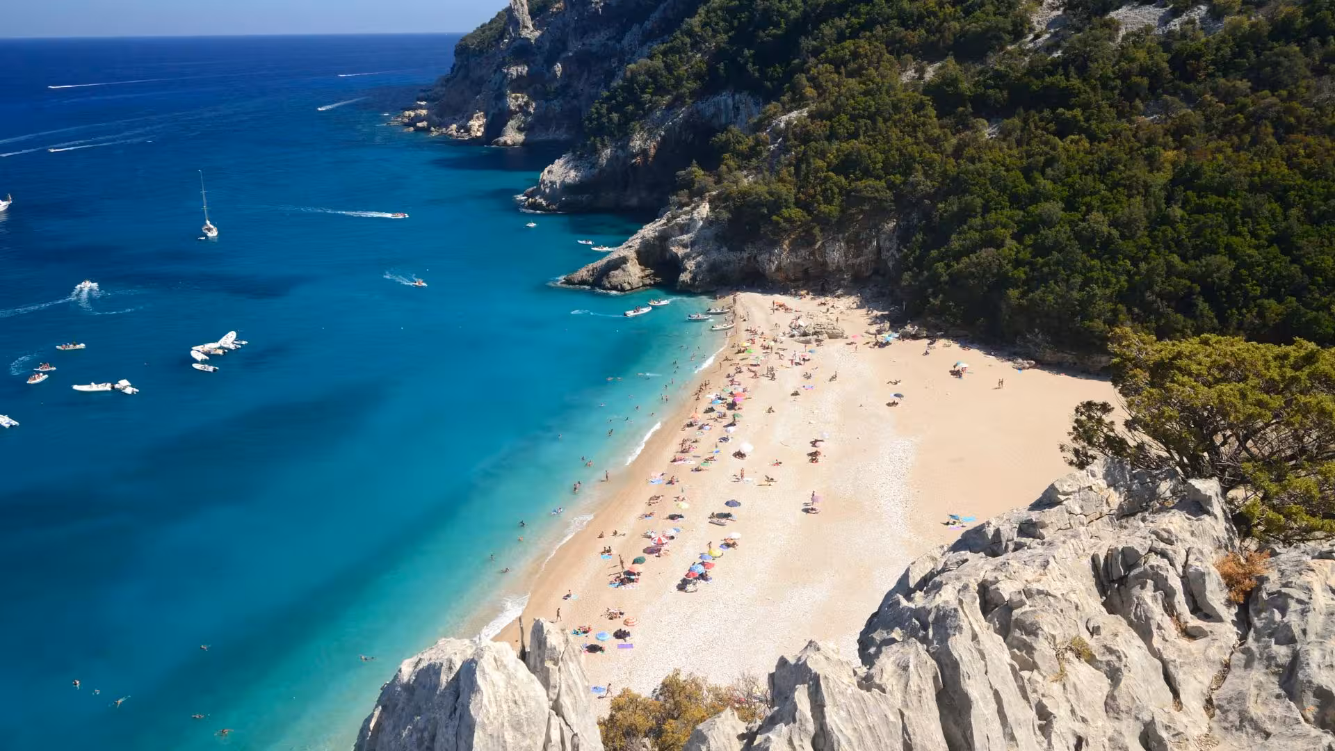 Scenic beach with turquoise waters and colorful umbrellas in the Gulf of Orosei, perfect for a relaxing day.