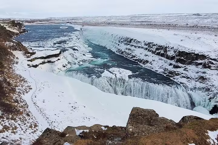 Snow-covered Gullfoss waterfall cascading into a frozen canyon on Iceland's iconic Golden Circle route