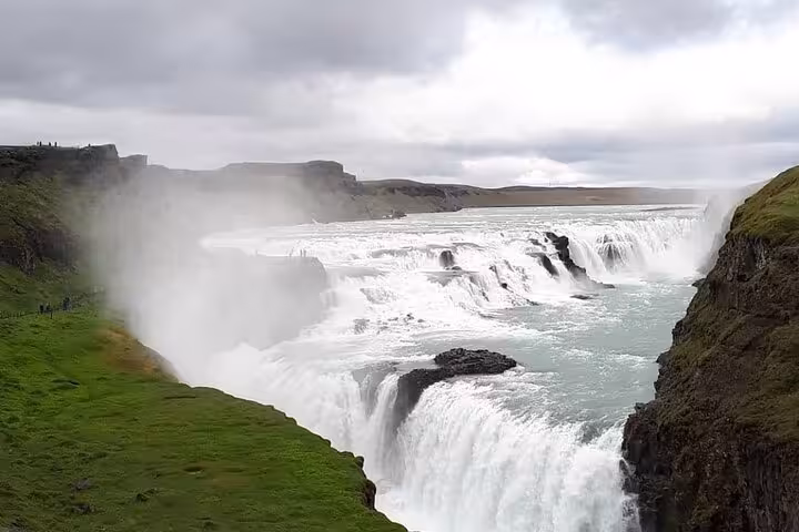 Gullfoss waterfall cascading into a canyon on Iceland's Golden Circle route under cloudy skies