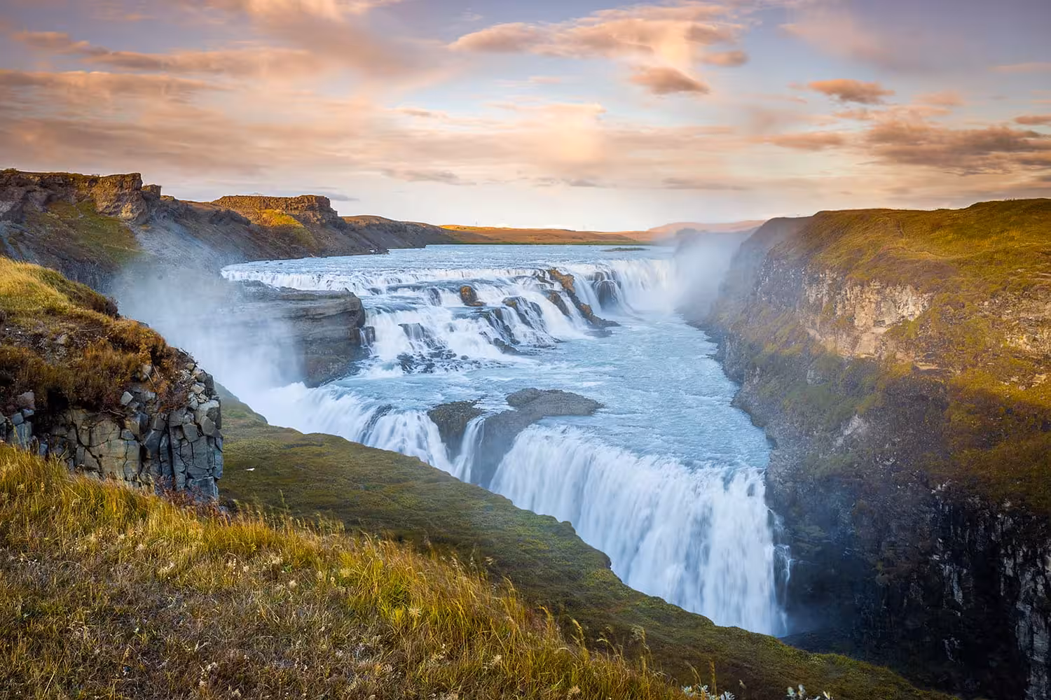 Gullfoss waterfall cascading into a canyon on Iceland's Golden Circle route at golden hour