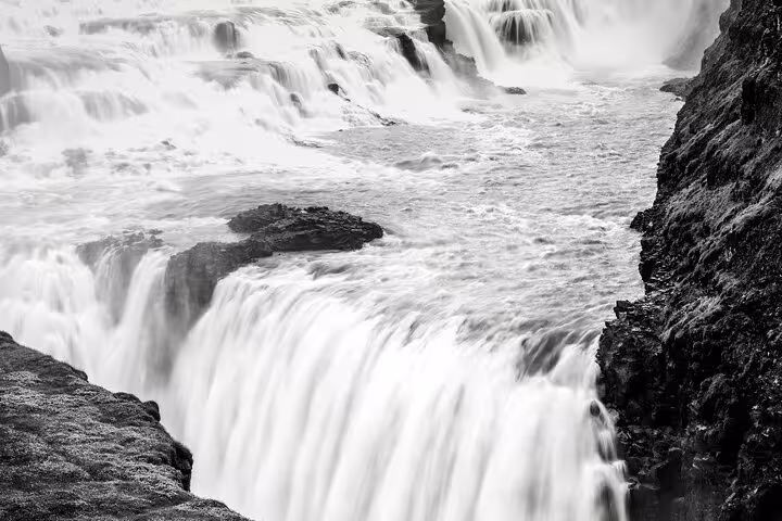 Powerful Gullfoss waterfall cascading into a rocky canyon in Iceland, black and white long exposure