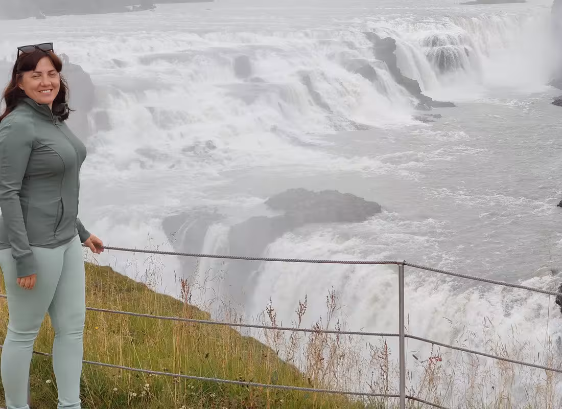 Woman smiling at Gullfoss waterfall on Iceland Golden Circle tour
