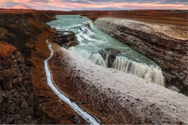 Gullfoss waterfall with icy edges and turquoise glacial river at sunset, Golden Circle Iceland