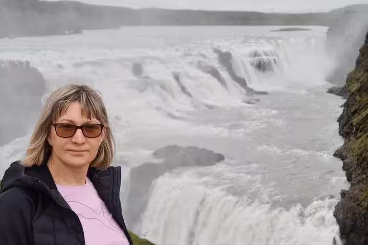 Woman posing at Gullfoss waterfall on Golden Circle tour from Keflavik Airport