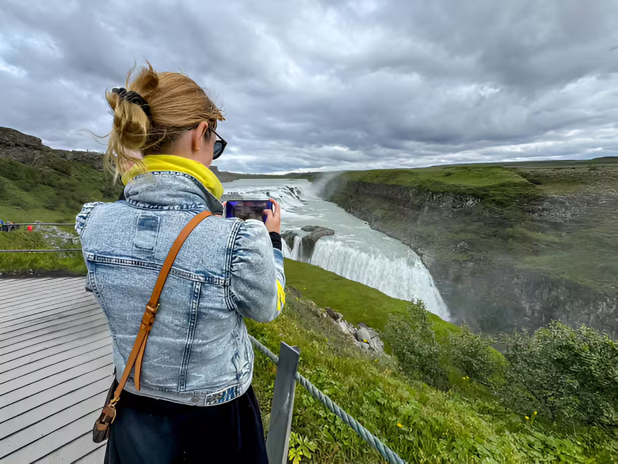 Tourist photographing Gullfoss waterfall on Golden Circle tour from Reykjavik cruise port