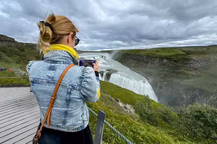 Tourist photographing Gullfoss waterfall on Golden Circle day trip from Reykjavik