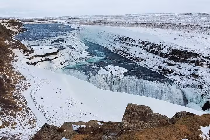 Snow-covered Gullfoss waterfall cascading into icy canyon on Golden Circle Super Jeep tour Iceland