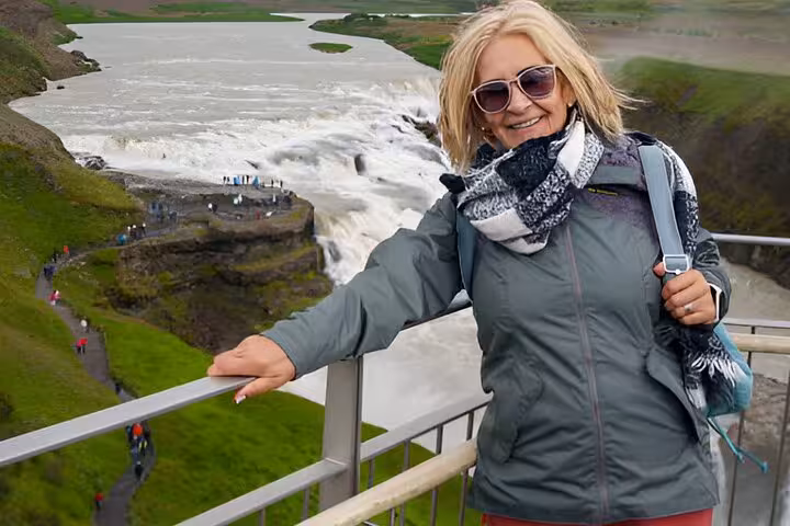Smiling woman at Gullfoss waterfall viewpoint on Golden Circle tour from Keflavik
