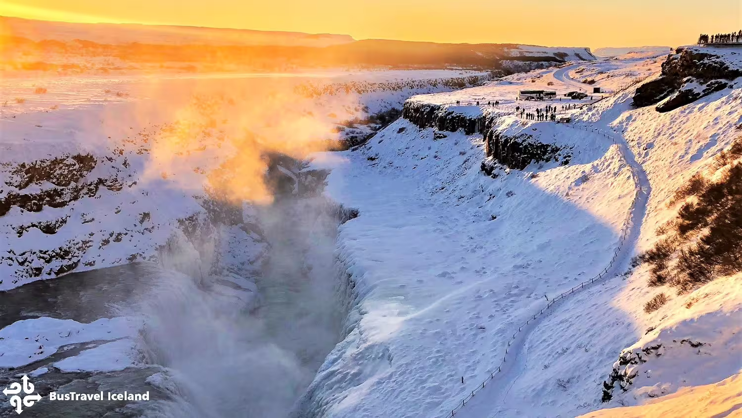 Gullfoss waterfall in winter with golden sunset sky and snow-covered canyon on Iceland's Golden Circle