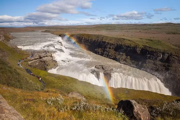 Gullfoss waterfall with double rainbow and visitors on viewing path, Golden Circle Iceland