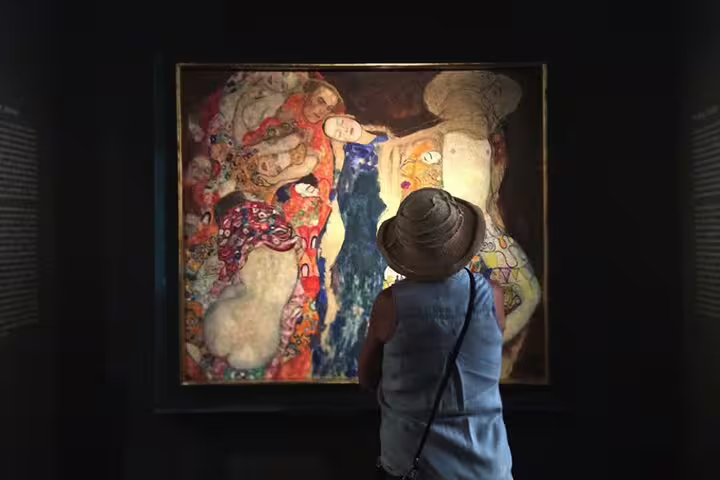 Visitor admiring Gustav Klimt's vibrant painting in Leopold Museum, part of the Vienna art tour experience.