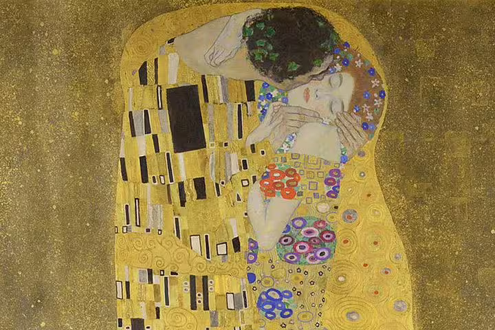 Gustav Klimt's iconic painting 'The Kiss' featuring a couple embracing, adorned in gold and colorful patterns.