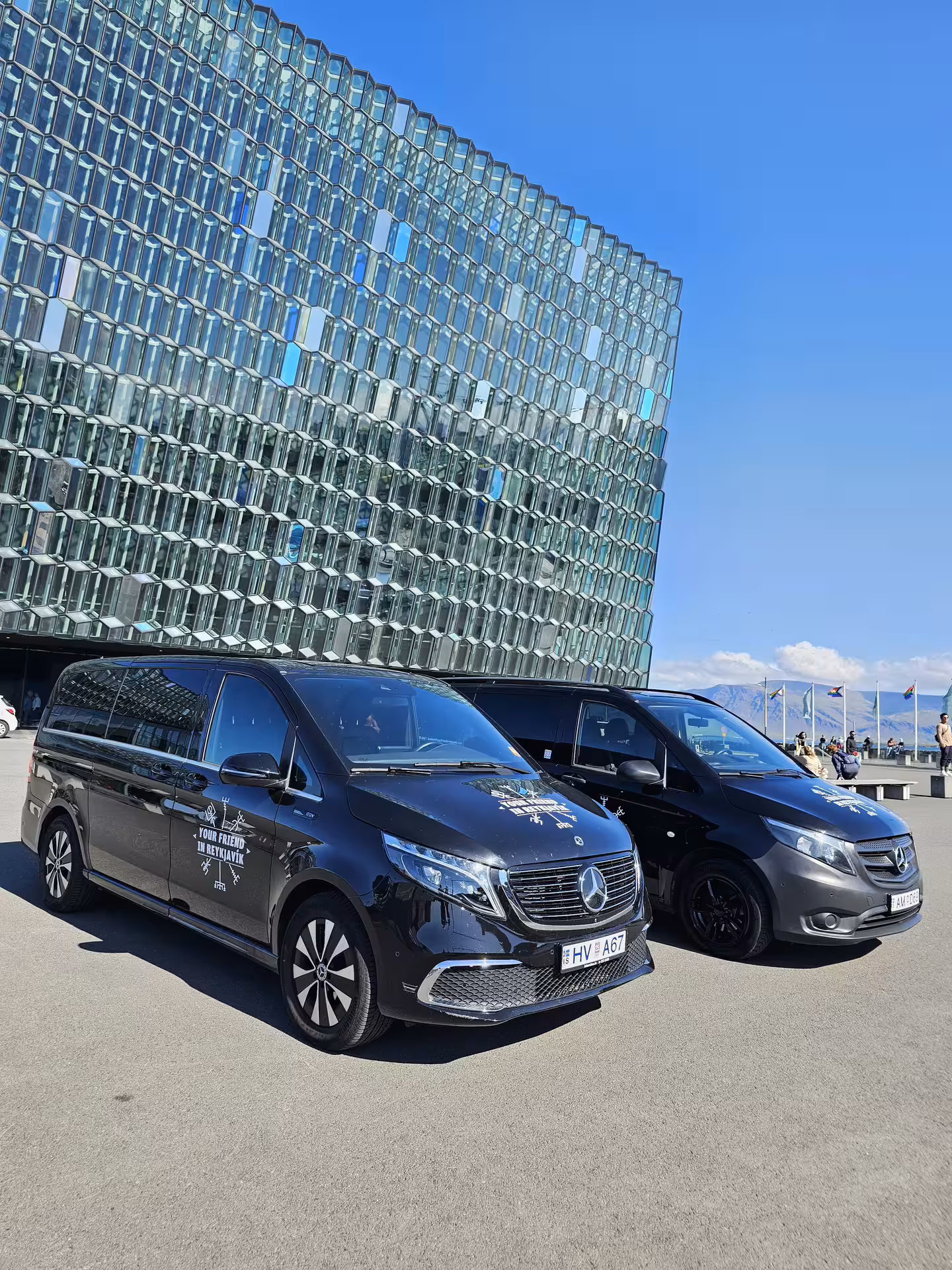 Two Tour Vehicles from Your Friend in Reykjavik parked in front of the Harpa Concert Hall in Reykjavik
