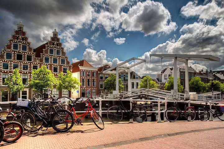 Bikes by a canal and drawbridge in Haarlem old town, Dutch gabled houses on a private walking tour