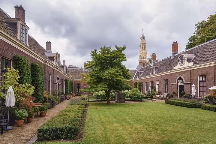 Historic Haarlem courtyard garden with brick buildings and church tower, seen on Highlight Bike Tours Haarlem