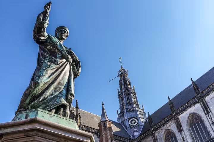 Statue and St Bavo Church tower in Haarlem, key stop on 2-hour walking tour of history and highlights
