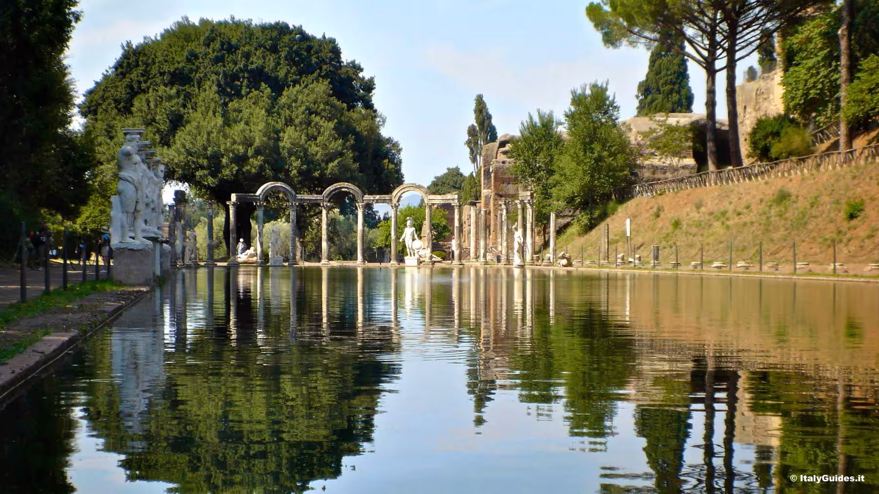 Explore Hadrian's Villa in Tivoli with its stunning pool reflecting ancient Roman statues and arches.